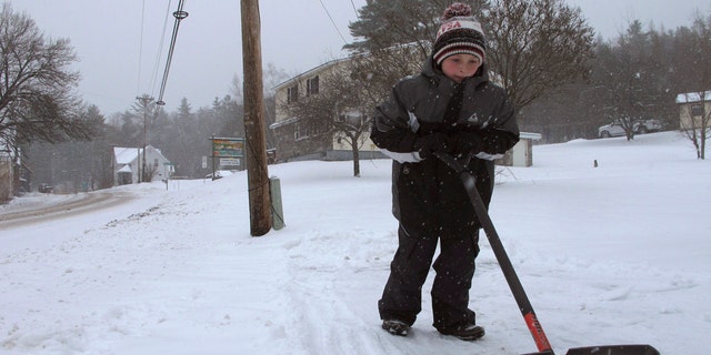 Kaiden Rogers shovels snow from his driveway on Tuesday, Nov. 12, 2019 in Marshfield, Vt.