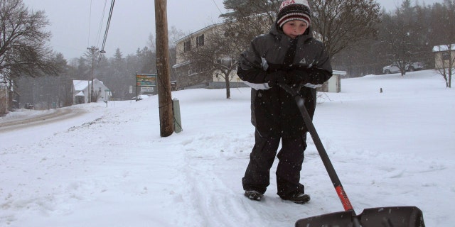 Kaiden Rogers shovels snow from his driveway on Tuesday, Nov. 12, 2019 in Marshfield, Vt.