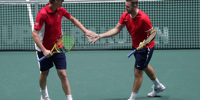 US Sam Querrey, right, and Jack Sock celebrate a point against Italy's Simone Bolelli and Fabio Fognini during their Davis Cup tennis match in Madrid, Spain, Thursday, Nov. 21, 2019. (AP Photo/Manu Fernandez)