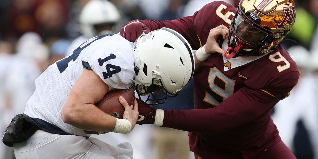 Minnesota defensive lineman Esezi Otomewo (9) grabs Penn State quarterback Sean Clifford (14) during an NCAA college football game Saturday, Nov. 9, 2019, in Minneapolis. Minnesota won 31-26. (AP Photo/Stacy Bengs)