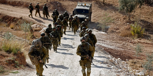 Israeli soldiers leave after an operation near the West Bank village of Bil'in, near Ramallah, on Oct. 22, 2013.