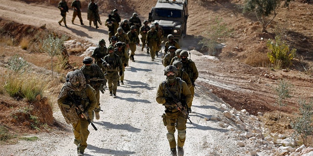 Israeli soldiers leave after an operation near the West Bank village of Bil'in, near Ramallah, on Oct. 22, 2013.