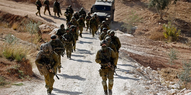 Israeli soldiers leave after an operation near the West Bank village of Bil'in near Ramallah on October 22, 2013.