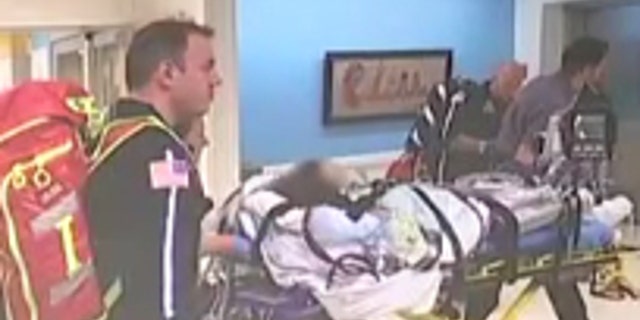 The teen, pictured during the hospital transfer,