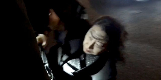 Hong Kong Justice Secretary Teresa Cheng gets up after falling when protesters surrounded her in London, on Nov. 14, 2019, in this still image from video obtained via social media. Chloe Leung via REUTERS 