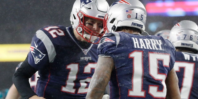 New England Patriots quarterback Tom Brady, left, celebrates his touchdown pass to wide receiver N'Keal Harry, right, in the first half of an NFL football game against the Dallas Cowboys, Sunday, Nov. 24, 2019, in Foxborough, Mass. (AP Photo/Elise Amendola)
