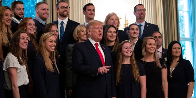 President Donald Trump stands with members of Queens University of Charlotte Swim Team during the NCAA Collegiate National Champions Day at the White House, Friday, Nov. 22, 2019, in Washington.