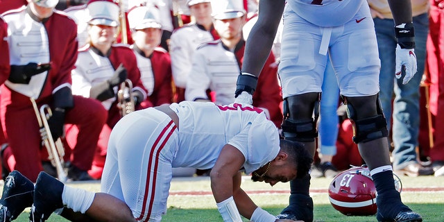 Alabama sive lineman Alex Leatherwood (70) checks on quarterback Tua Tagovailoa (13) after he was injured in the first half of an NCAA college football game against Mississippi State in Starkville, Miss., Saturday, Nov. 16, 2019. Alabama won 38-7. (AP Photo/Rogelio V. Solis)