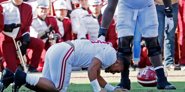 Alabama sive lineman Alex Leatherwood (70) checks on quarterback Tua Tagovailoa (13) after he was injured in the first half of an NCAA college football game against Mississippi State in Starkville, Miss., Saturday, Nov. 16, 2019. Alabama won 38-7. (AP Photo/Rogelio V. Solis)