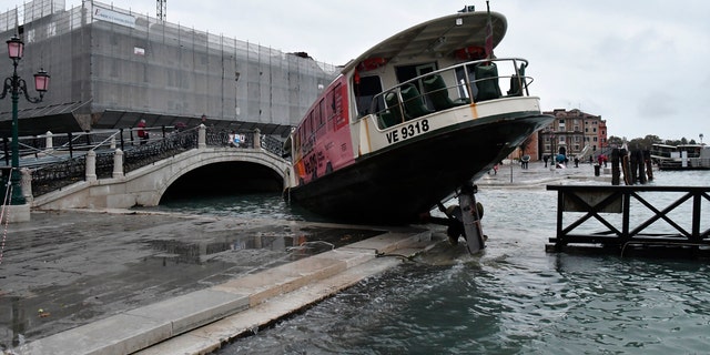 A stranded ferry boat lies on its side, in Venice, Wednesday, Nov. 13, 2019.