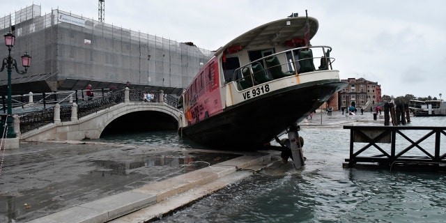A stranded ferry boat lies on its side, in Venice, Wednesday, Nov. 13, 2019.