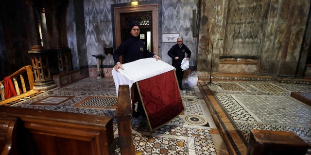 Workers clean up after high waters flooded the interior of St. Mark's Basilica, in Venice, Wednesday, Nov. 13, 2019.