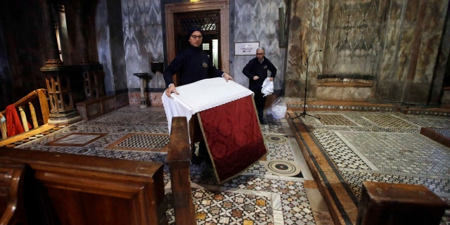 Workers clean up after high waters flooded the interior of St. Mark's Basilica, in Venice, Wednesday, Nov. 13, 2019.