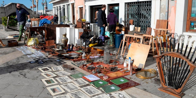 Sketches and drawings are lined up to dry up outside an art store following a flooding in Venice, Italy, Thursday, Nov. 14, 2019.