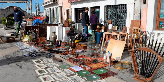 Sketches and drawings are lined up to dry up outside an art store following a flooding in Venice, Italy, Thursday, Nov. 14, 2019.