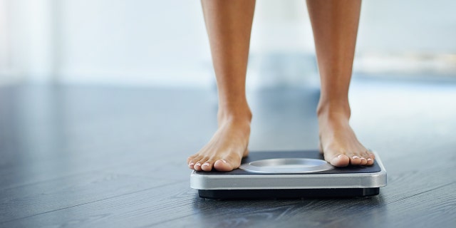 Shot of a woman weighing herself at home. (Photo: iStock)