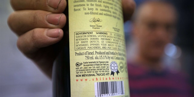 Amichai Luria presents a bottle of his wine, used mainly for export, at the Shilo winery in the Jewish settlement of Shilo in the occupied West Bank on November 12, 2015. The European Union announced that goods from settlements -- Jewish communities built in areas occupied by force in 1967 -- must be specifically labelled, infuriating Israel. The EU ruling affects products imported from settlements in the occupied West Bank, east Jerusalem and Golan Heights, all taken by Israel in the 1967 Six-Day War.