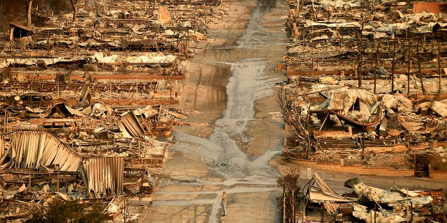 A man stands in the middle of the Seminole Springs mobile home park in Malibu, Calif. after the Woolsey Fire roared through the community on Nov. 10, 2018. (Photo by Wally Skalij/Los Angeles Times via Getty Images)