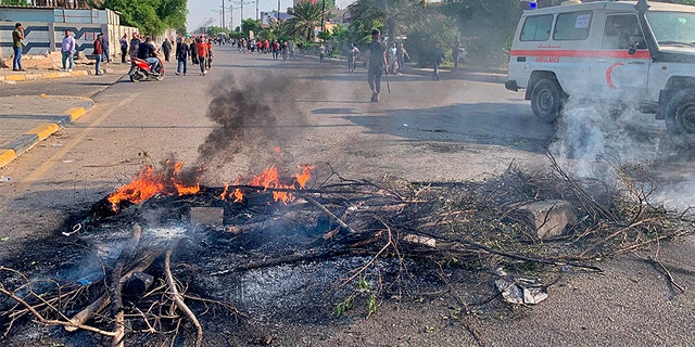 Protesters set fire to close a street in Sadr City during the ongoing anti-government protests in Baghdad, Iraq, on Monday. (AP)