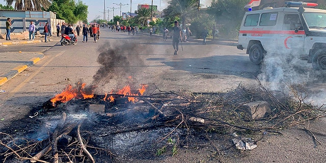 Protesters set fire to close a street in Sadr City during the ongoing anti-government protests in Baghdad, Iraq, on Monday. (AP)