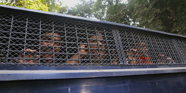 Members of the militant group shout slogans from inside a police van after their sentence was announced Wednesday. (AP)