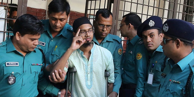 Police escort a member of a banned militant group after he was sentenced to death for an attack on a cafe that killed more than 20 people in Dhaka, Bangladesh, in 2016. (AP)