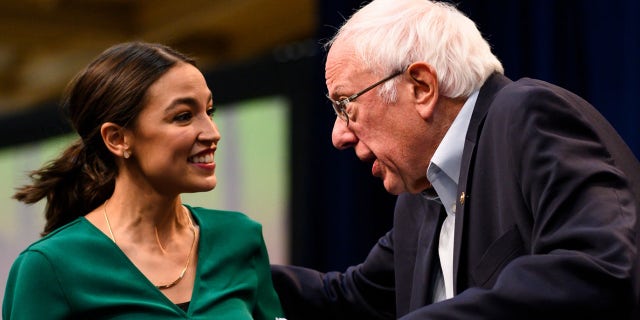 Rep. Alexandria Ocasio-Cortez is joined on stage by Democratic presidential candidate Bernie Sanders during the climate crisis summit at Drake University on Nov. 9, 2019, in Des Moines, Iowa.