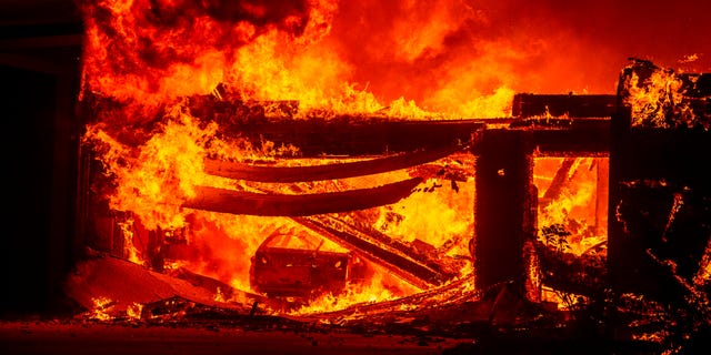A car burns in a garage as a home goes up in flames during the Hillside fire in the North Park neighborhood of San Bernardino, Calif., on Thursday.
