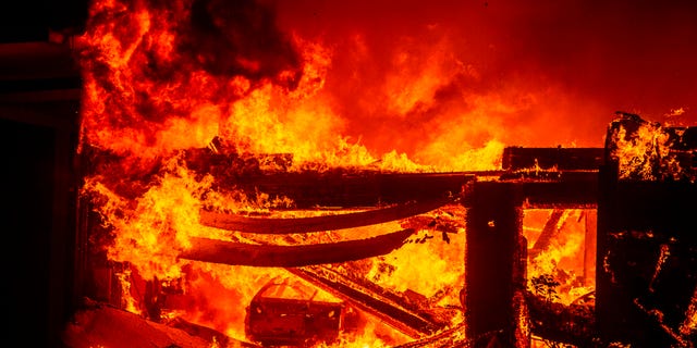 A car burns in a garage as a home goes up in flames during the Hillside fire in the North Park neighborhood of San Bernardino, Calif., on Thursday.