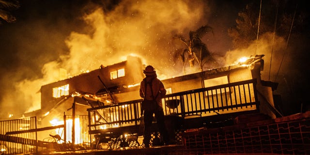 Firefighters work to control the flames as the embers blown by the wind threaten more homes in the North Park neighborhood at the Hillside Fire in San Bernardino on Thursday. (Photo by Marcus Yam/Los Angeles Times via Getty Images)