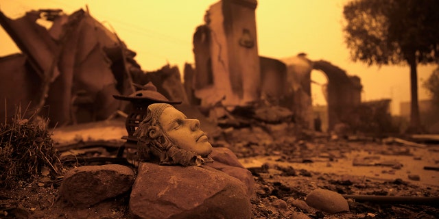 The burned remains of a home destroyed by the Camp Fire in Paradise, Calif., in November 2018. Since last year, only a handful of homes have been rebuilt in the community that lost nearly 9,000 residences in the wildfire. (AP Photo/Rich Pedroncelli, File)