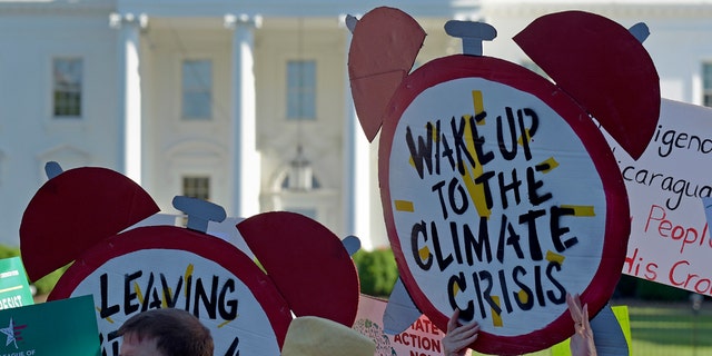FILE- In this June 1, 2017 file photo, protesters gather outside the White House in Washington to protest President Donald Trump's decision to withdraw the Unites States from the Paris climate change accord.  (AP Photo/Susan Walsh)
