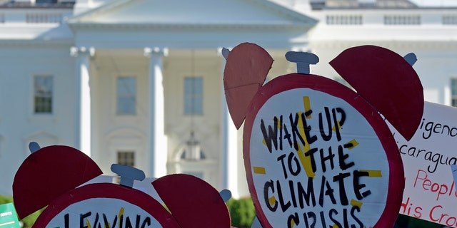 FILE- In this June 1, 2017 file photo, protesters gather outside the White House in Washington to protest President Donald Trump's decision to withdraw the Unites States from the Paris climate change accord.  (AP Photo/Susan Walsh)