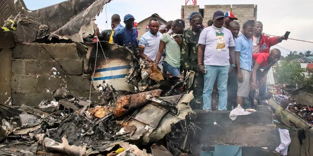 Rescuers and onlookers gather amidst the debris of an aircraft that crashed in Goma, Congo on Sunday. (AP Photo/Justin Kabumba)
