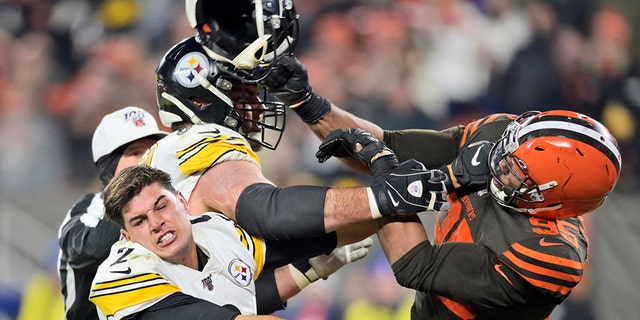 Cleveland Browns defensive end Myles Garrett (95) hits Pittsburgh Steelers quarterback Mason Rudolph (2) with a helmet during the second half of an NFL football game Thursday, Nov. 14, 2019, in Cleveland. (Associated Press)