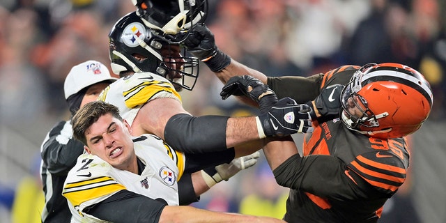 Cleveland Browns defensive end Myles Garrett (95) hits Pittsburgh Steelers quarterback Mason Rudolph (2) with a helmet during the second half of an NFL football game Thursday, Nov. 14, 2019, in Cleveland. (Associated Press)