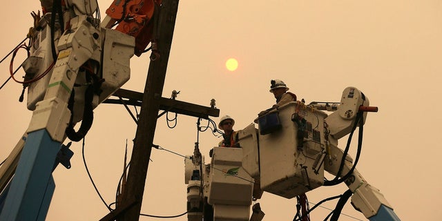 Nov. 9, 2018: Pacific Gas & Electric crews work to restore power lines in Paradise, Calif. (AP Photo/Rich Pedroncelli)