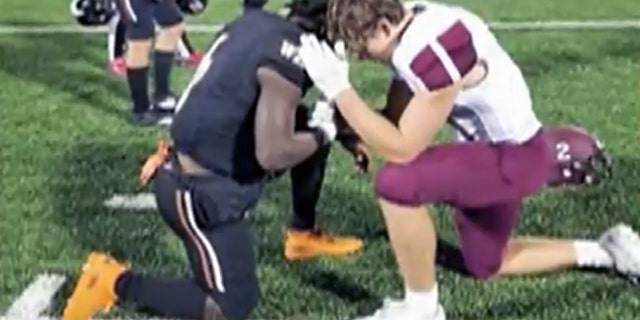 Sherman High School senior Gage Smith was seen kneeling down with West Mesquite High School player Ty Jordan as they prayed for Jordan’s mother, who is battling cancer.