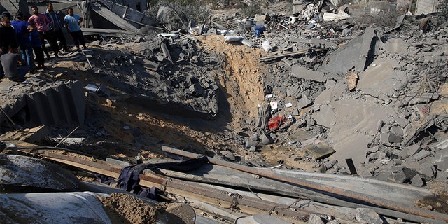 Palestinians inspect a crater and the rubble of destroyed houses following Israeli missile strikes, in Al-Qarara, east of Khan Younis, earlier this week.