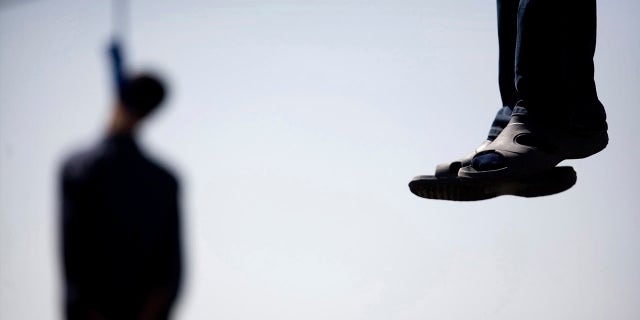 Majid Kavousifar and Hossein Kavousifar, his nephew, hang from the cable of a crane in Tehran, Aug. 2, 2007. Iran hanged Majid and Hossein, the killers of a judge who had jailed several reformist dissidents, before a crowd of hundreds of people.