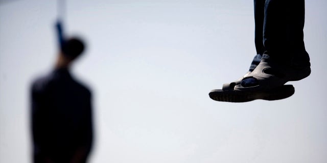 Majid Kavousifar and Hossein Kavousifar, his nephew, hang from the cable of a crane in Tehran, Aug. 2, 2007. Iran hanged Majid and Hossein, the killers of a judge who had jailed several reformist dissidents, before a crowd of hundreds of people. 