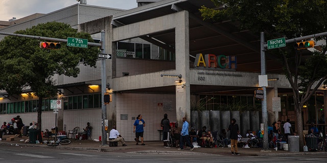 Homeless men and women are gathered outside of the Austin Resource Center for the Homeless in downtown Austin, Texas, on August 14, 2019. 