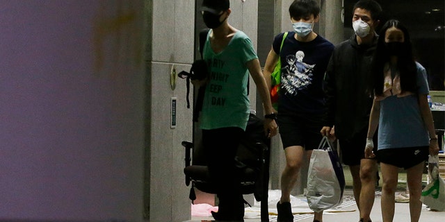 Protesters walk inside the campus of Polytechnic University in Hong Kong on Friday. Most of the protesters who took over the university last week have left, but an unknown number have remained inside for days, hoping somehow to avoid arrest. (AP)