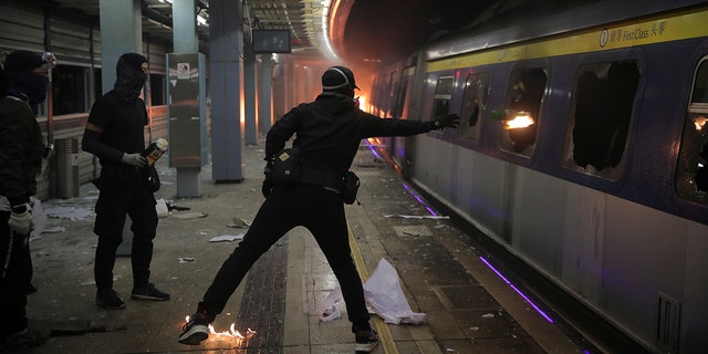 Students continued the 5-month-old anti-government movement. Some hurled Molotov cocktails at a parked train on a university campus. (AP Photo/Kin Cheung)