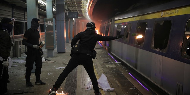 Students continued the 5-month-old anti-government movement. Some hurled Molotov cocktails at a parked train on a university campus. (AP Photo/Kin Cheung)