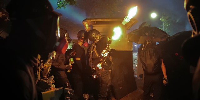 On Tuesday, police and protesters engaged in a day-long battled outside university campuses. Several thousand demonstrators also blocked roads as they took over a central business district. (AP Photo/Kin Cheung)