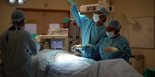 A surgical team prepare a patient ahead of performing an operation at Milton Keynes University Hospital in Milton Keynes, central England, Britain, May 23, 2018. A recent report shows England's NHS system is failing to meet several of its standards regarding patient wait times.