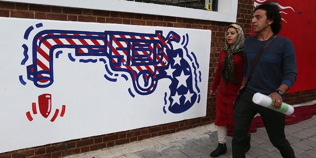 Iranians walk past a new mural painted on the walls of the former US embassy in the capital Tehran on November 2, 2019. (Photo by ATTA KENARE / AFP) (Photo by ATTA KENARE/AFP via Getty Images)