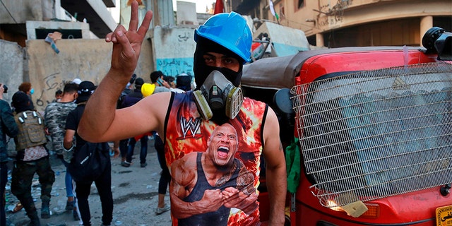 An anti-government protester flashing a victory sign in Baghdad on Sunday.