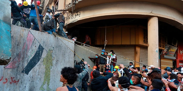 Demonstrators trying to pull down concrete walls placed by Iraqi security forces to close in the historic Rasheed Street in Baghdad on Sunday.